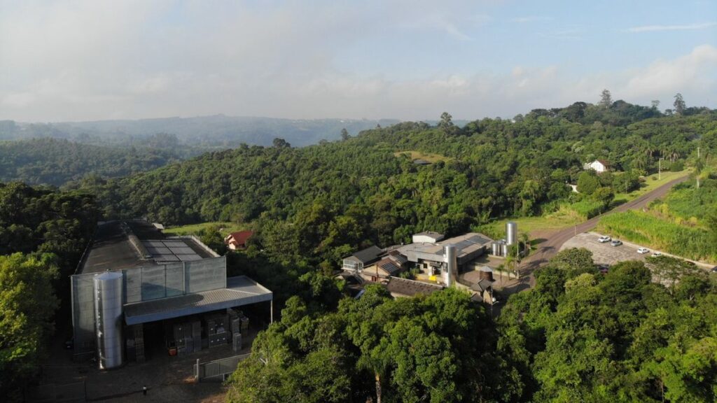 Vista aérea da destilaria Weber Haus em meio à vegetação de Ivoti/RS, destacando a integração da estrutura com a natureza ao redor.